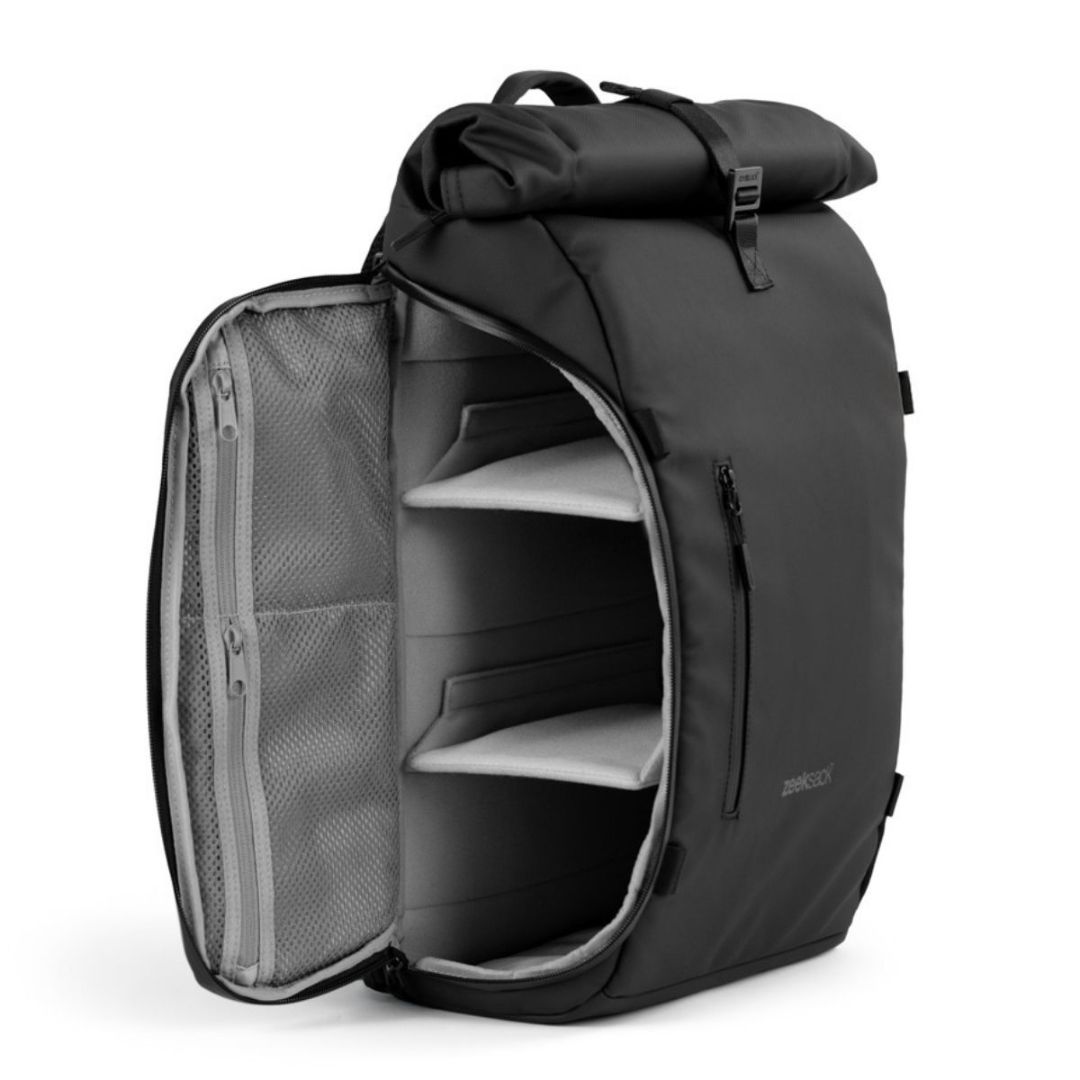 En stilren svart rolltop-ryggsäck som är öppnad från sidan och tom inuti.