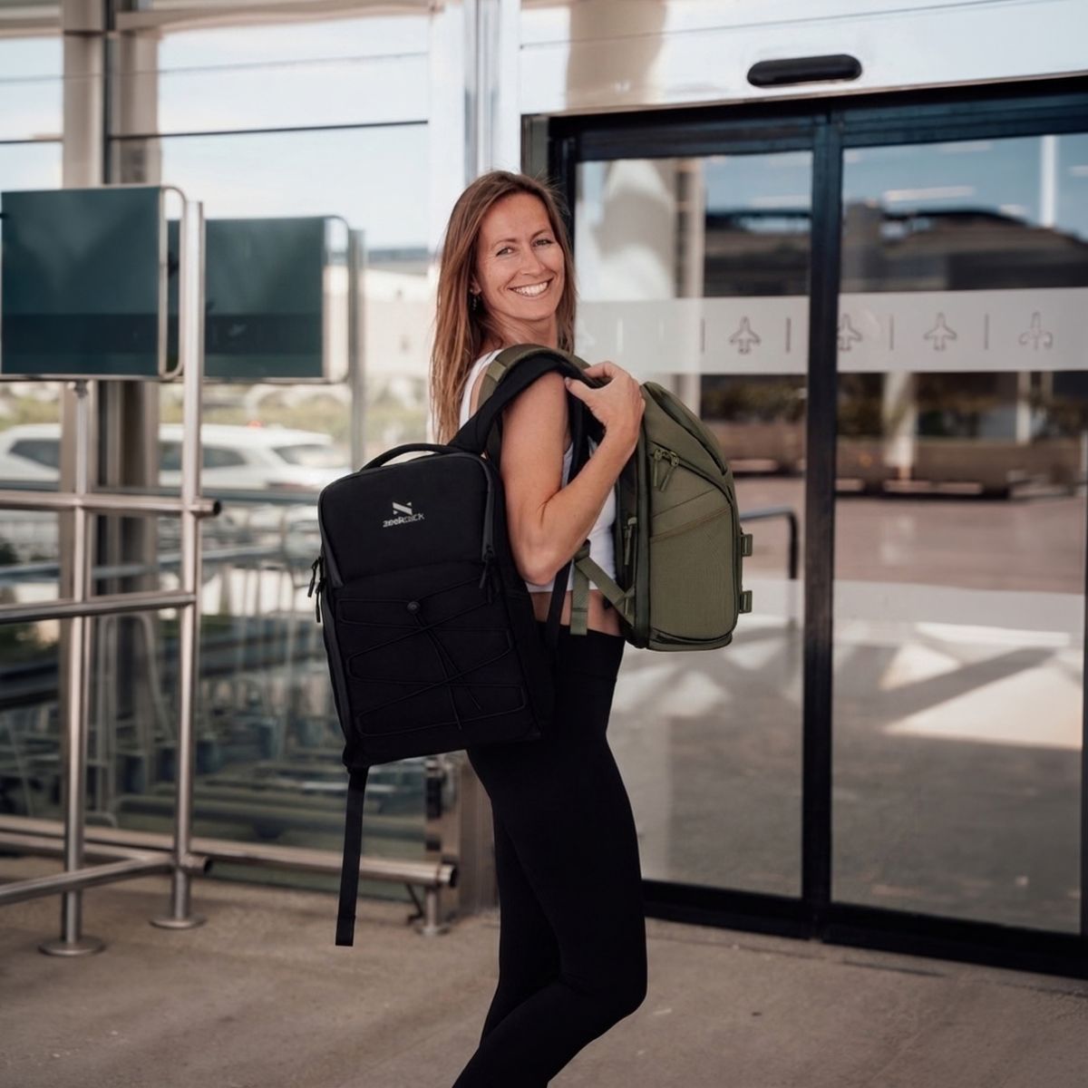 Zeeksack - Kvinna som bär två The Underseat 15L i svart och Ranger Green.