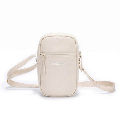 Zeeksack Travel Pouch i Sand White med ljusbeige axelrem och framficka.