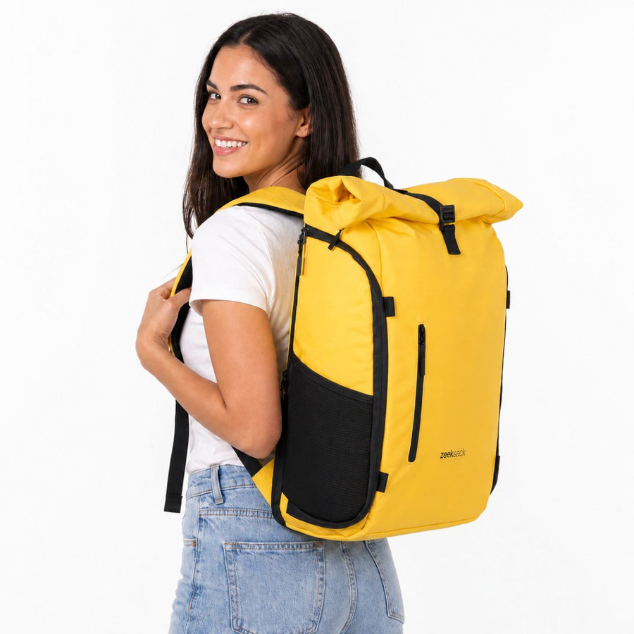 Kvinna med Zeeksack The Rolltop 25L i Solar Yellow på ryggen.