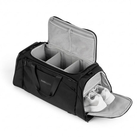 En svart duffelbag med organiserade fack och separat skofack med vita skor.