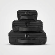 Tre svarta Zeeksack Expandable Packing Cubes i olika storlekar staplade ovanpå varandra.