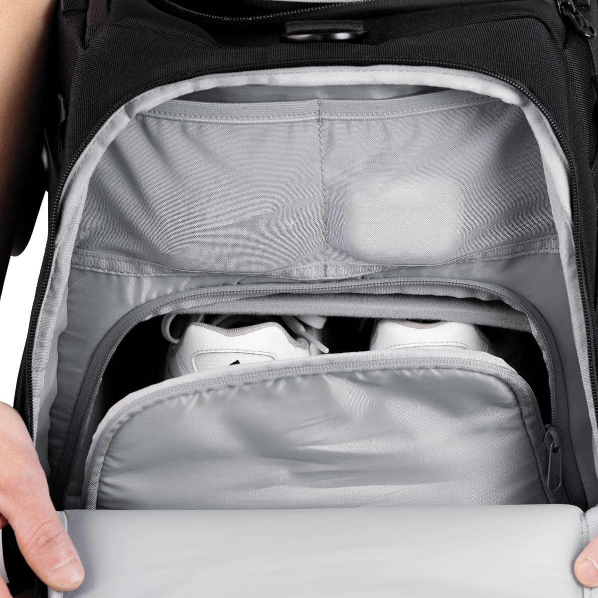 Skor som ligger i separat skofack på väska samt mindre accessoarer i fack ovanför